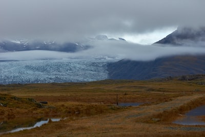 白昼白云下山旁绿草如茵